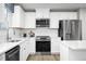 Modern kitchen featuring white cabinets, stainless steel appliances, quartz countertops, and a stylish backsplash at 303 Rothbury Ct, Sanford, NC 27330