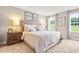 Cozy main bedroom showcasing a large bed, soft lighting, and windows offering views of the outdoors at 303 Rothbury Ct, Sanford, NC 27330