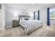 Comfortable main bedroom featuring soft blue walls, plush carpet, and large windows for natural light at 303 Rothbury Ct, Sanford, NC 27330