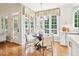 A bright breakfast nook features an abundance of windows, hardwood floors, and a modern chandelier at 305 Promontory Point Dr, Cary, NC 27513