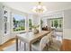 A bright dining room boasts large windows with backyard views, hardwood floors, stylish light fixture and wallpaper at 305 Promontory Point Dr, Cary, NC 27513