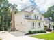 View of the home's exterior showcasing a brick chimney, attached garage, and well-maintained lawn at 305 Promontory Point Dr, Cary, NC 27513