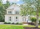 Charming two-story home boasts a meticulously landscaped front yard and classic architectural details at 305 Promontory Point Dr, Cary, NC 27513