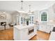 A sun-filled kitchen features a large island, white cabinets, stainless steel appliances, and an open floor plan at 305 Promontory Point Dr, Cary, NC 27513