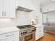 A modern kitchen features white cabinetry, stainless steel appliances, marble countertops, and a herringbone backsplash at 305 Promontory Point Dr, Cary, NC 27513