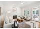 A bright living room offers a fireplace, hardwood floors, neutral furniture, and lots of natural light at 305 Promontory Point Dr, Cary, NC 27513