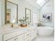 Bright main bathroom with double vanity, soaking tub, and elegant gold fixtures at 305 Promontory Point Dr, Cary, NC 27513