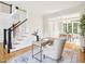 Well-lit office with hardwood floors and a view of dining area. Staircase and entrance in the background at 305 Promontory Point Dr, Cary, NC 27513