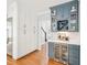 A butler's pantry area with custom cabinets, wine storage, beverage cooler and hardwood floors at 305 Promontory Point Dr, Cary, NC 27513
