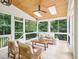 A screened porch features skylights, ceiling fan, cozy seating, and a beautiful view of the backyard at 305 Promontory Point Dr, Cary, NC 27513