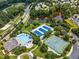 Aerial view showcasing a community pool, clubhouse, tennis courts, and serene pond surrounded by lush trees at 306 Berlin Way, Morrisville, NC 27560
