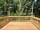 Picture of the back deck of the home with wood planks and railings overlooking trees in the background at 311 Rothbury Ct, Sanford, NC 27330