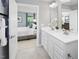 Bright bathroom showcasing double sinks, white cabinets, modern fixtures, and an open doorway to the bedroom at 311 Rothbury Ct, Sanford, NC 27330