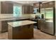 Well-lit kitchen featuring stainless steel appliances, granite countertops, and wood cabinets at 311 Rothbury Ct, Sanford, NC 27330