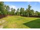 Wide shot of backyard, enclosed with a privacy fence and mature landscaping at 315 Watchmen Ln, Cameron, NC 28326