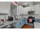 Bright kitchen featuring stainless steel appliances, granite countertops, and stylish blue and white cabinetry at 315 Watchmen Ln, Cameron, NC 28326
