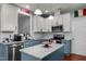 Stylish kitchen boasts white cabinets, blue island with granite countertops, and stainless steel appliances at 315 Watchmen Ln, Cameron, NC 28326