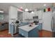 Bright kitchen with white and blue cabinets, granite counters, stainless appliances, and modern lighting at 315 Watchmen Ln, Cameron, NC 28326
