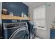Modern laundry room features side-by-side washer and dryer and navy shiplap accent wall at 315 Watchmen Ln, Cameron, NC 28326
