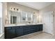 Bathroom with double vanity featuring white countertop, navy cabinets, and two mirrors with vanity lighting at 316 Levi Ln, Wake Forest, NC 27587
