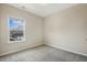 Neutral bedroom with plush carpeting and a window with a view of a house at 316 Levi Ln, Wake Forest, NC 27587