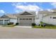 View of a detached garage with a light gray door and siding, with a paved driveway at 316 Levi Ln, Wake Forest, NC 27587