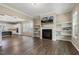 Open-concept living room featuring a fireplace, floating shelves, and wood flooring at 316 Levi Ln, Wake Forest, NC 27587