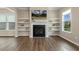Inviting living room featuring a fireplace, floating shelves, and wood flooring at 316 Levi Ln, Wake Forest, NC 27587