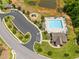 Aerial view of community pool, parking, playground, with surrounding landscaping, providing amenities for residents at 33 E Ravano Dr, Clayton, NC 27527