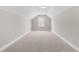 Finished attic features neutral walls, plush carpet, and a window offering natural light at 33 E Ravano Dr, Clayton, NC 27527