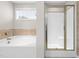 Bright bathroom featuring a soaking tub with tile surround and a glass-enclosed shower at 33 E Ravano Dr, Clayton, NC 27527