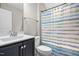Bathroom with a blue striped shower curtain, marble vanity, and brushed nickel faucet at 33 E Ravano Dr, Clayton, NC 27527