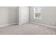 Carpeted bedroom featuring a double door closet and bright natural light at 33 E Ravano Dr, Clayton, NC 27527