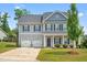 Charming two-story home features a manicured lawn and attached two-car garage at 33 E Ravano Dr, Clayton, NC 27527