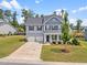 Aerial view of a two-story home with manicured lawn, landscaping, and two-car garage at 33 E Ravano Dr, Clayton, NC 27527