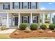 Home's front porch features white columns, a gray front door, and landscaping at 33 E Ravano Dr, Clayton, NC 27527