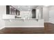 Modern kitchen with dark cabinets and a granite breakfast bar overlooking the living and dining areas at 33 E Ravano Dr, Clayton, NC 27527