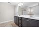 Main bathroom featuring a double sink vanity with dark cabinets, tile flooring and updated fixtures at 33 E Ravano Dr, Clayton, NC 27527