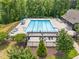Community pool with lounge chairs, pergolas, and a clear swimming area surrounded by a green area and trees at 33 E Ravano Dr, Clayton, NC 27527