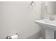 A well-lit powder room featuring a pedestal sink, round mirror and updated fixtures at 33 E Ravano Dr, Clayton, NC 27527