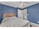 A soothing bedroom featuring blue walls, ceiling fan, carpet, and a white closet door at 342 Westgrove Ct, Durham, NC 27703