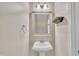 Stylish half bathroom with a pedestal sink, decorative mirror, and modern fixtures at 342 Westgrove Ct, Durham, NC 27703