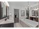Bright bathroom featuring double sinks, soaking tub, chandelier, and a view into the bedroom at 4105 Bankshire Ln, Raleigh, NC 27603