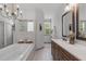 Well-lit bathroom featuring a soaking tub, custom vanity with granite countertop, and tiled floor at 4105 Bankshire Ln, Raleigh, NC 27603