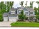 Inviting blue two-story home with stone accents, three-car garage, and well-maintained lawn at 4105 Bankshire Ln, Raleigh, NC 27603
