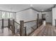 Upstairs landing hallway with hardwood floors and decorative metal and wood railing at 4105 Bankshire Ln, Raleigh, NC 27603