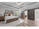 Cozy main bedroom featuring a ceiling fan, closet with rustic sliding barn door, and neutral decor at 4105 Bankshire Ln, Raleigh, NC 27603