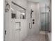 Walk-in shower featuring multi-head shower system, inset shelf, and a view into the rest of the bathroom at 4105 Bankshire Ln, Raleigh, NC 27603