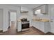 Well-lit kitchen with stainless steel appliances, wood countertops, and white cabinetry at 414 Craven St, Durham, NC 27704