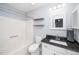 Well-lit bathroom features a vanity with granite countertop, a tub, and shelves at 4604 Townesbury Ln, Raleigh, NC 27612